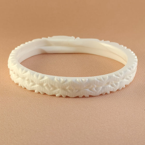 Decorative white bangle on a beige background